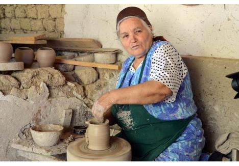 ÎNCĂPĂŢÂNARE. Din 90 de familii care făceau olărit în Vadu Crişului, localitate celebră pentru ceramica albă din lutul lipsit de oxizi coloranţi, au mai rămas abia trei care duc meşteşugul mai departe. Nana Iulişca (foto) e chiar mirată că străinii îl preţuiesc mai mult decât românii